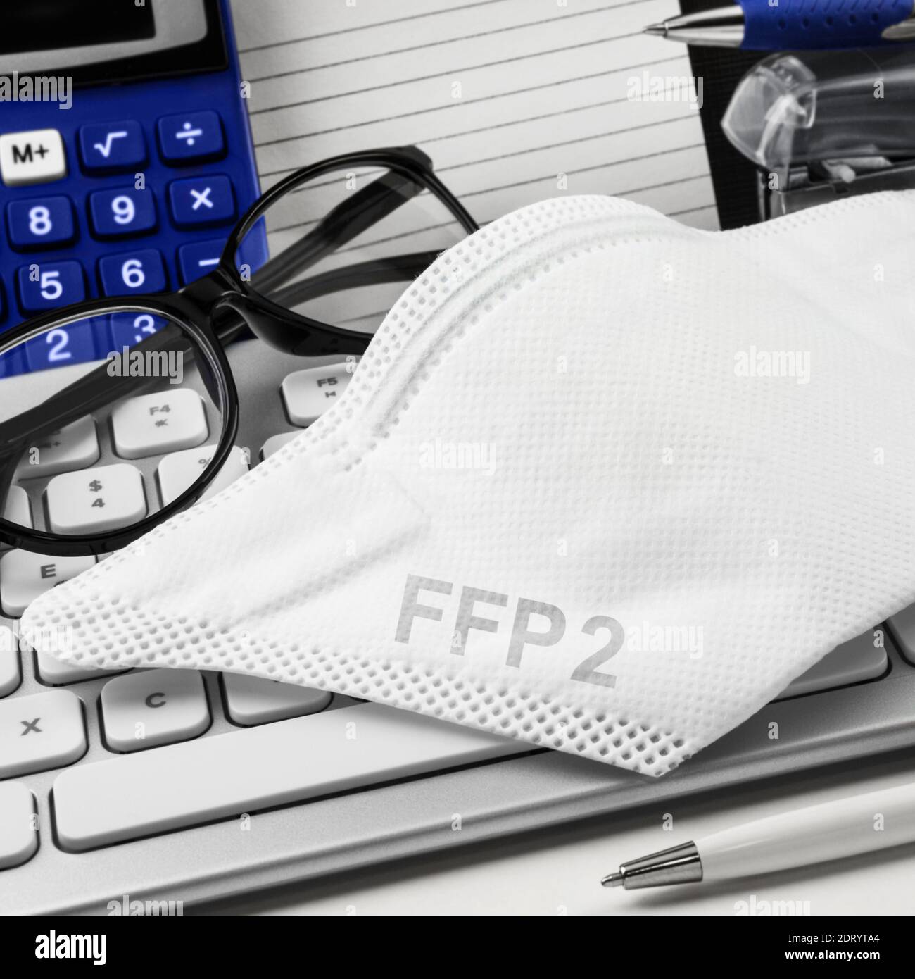FFP 2 Maske am Arbeitsplatz mit teclado de PC Foto de stock