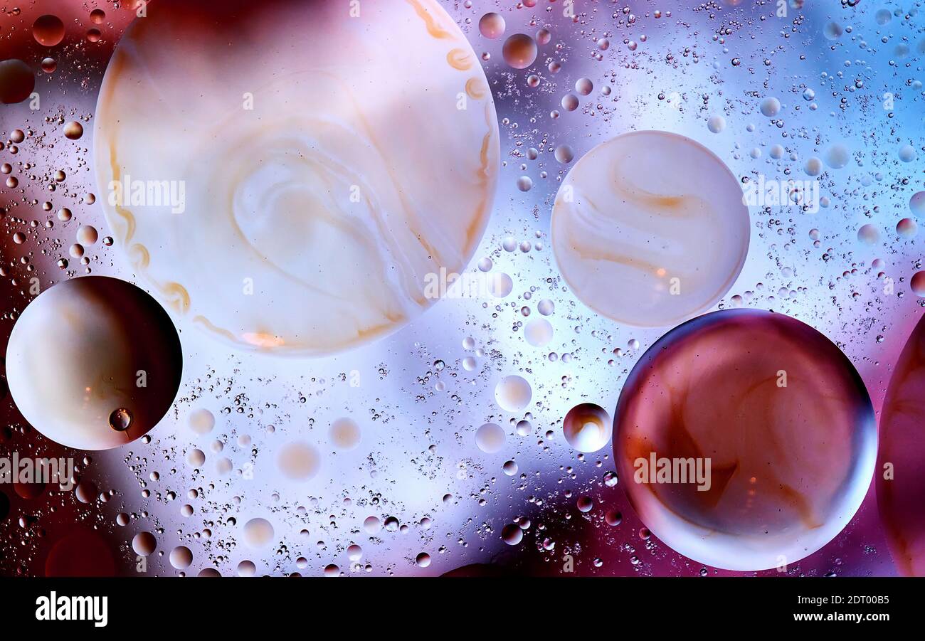 Burbujas con rayas marrones entre pequeñas gotas abstractamente contra un fondo brillante Foto de stock