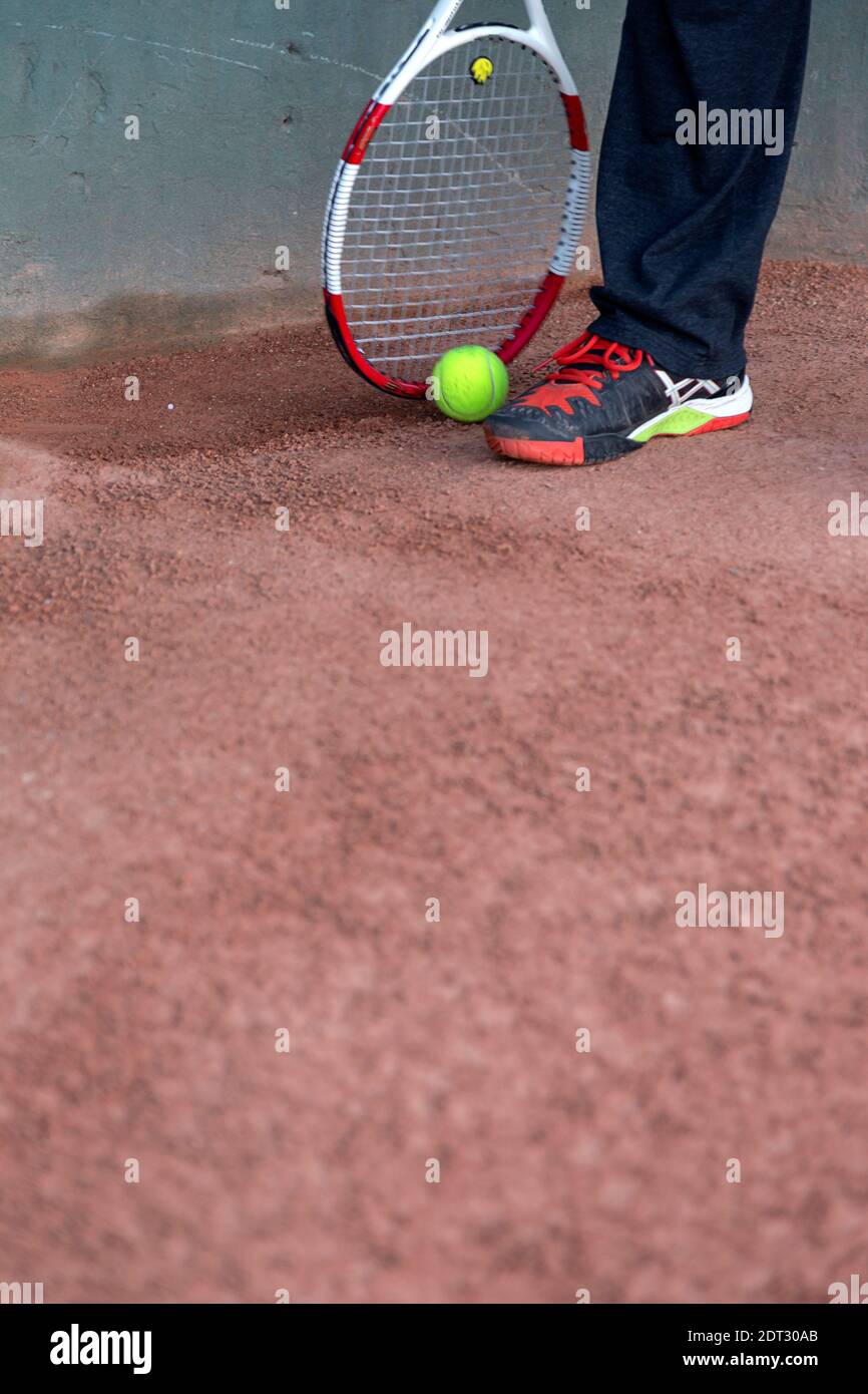 Sección baja del hombre con pelota de tenis y raqueta Foto de stock