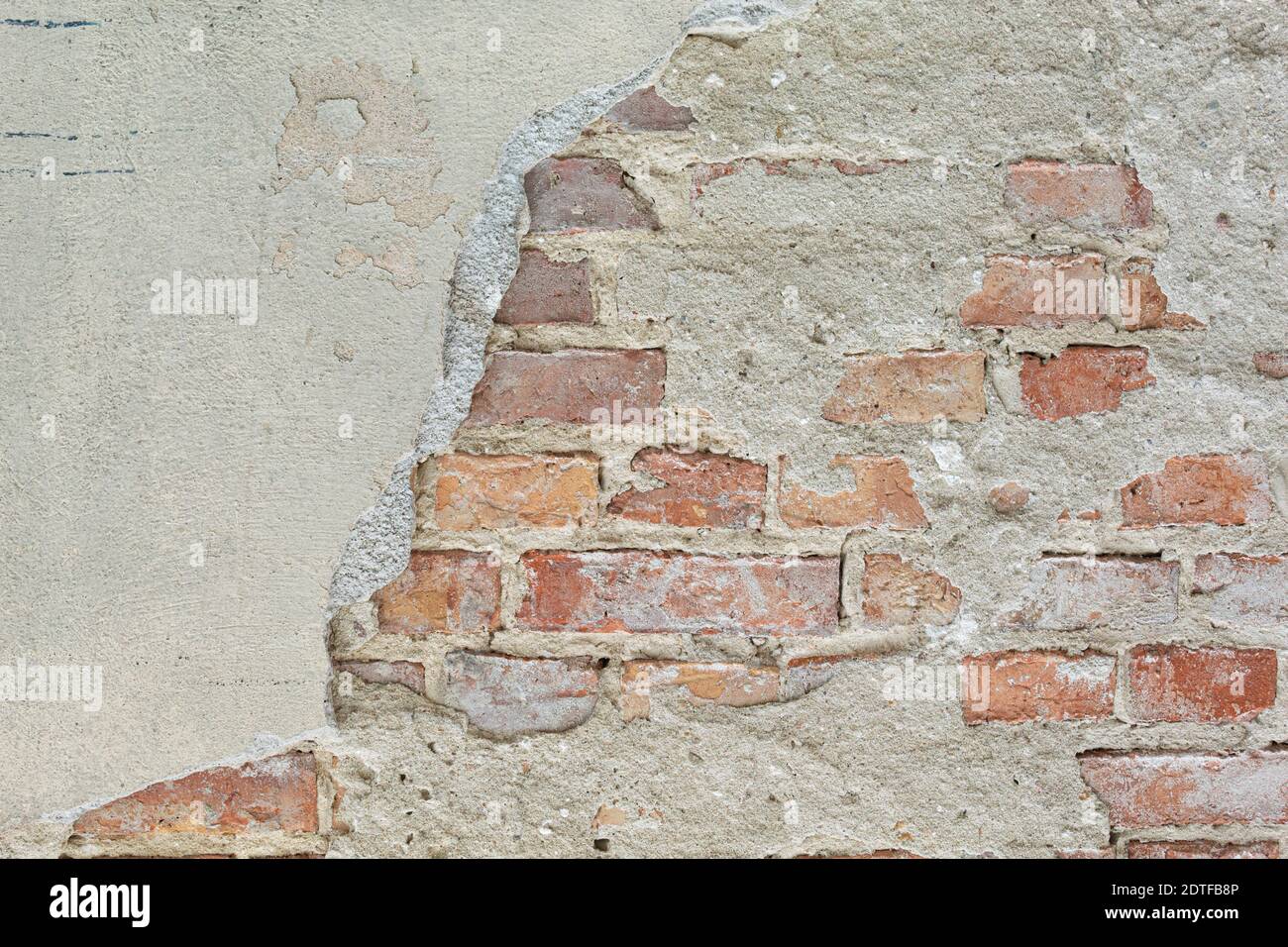 La textura de la piedra y el yeso caído. Caída de yeso y pared de piedra roja Foto de stock