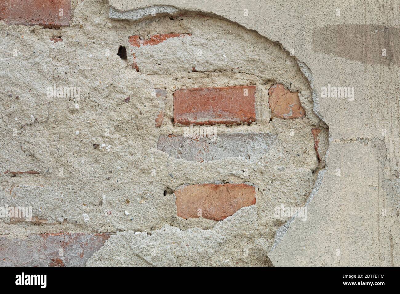 La textura de la piedra y el yeso caído. Caída de yeso y pared de piedra roja Foto de stock
