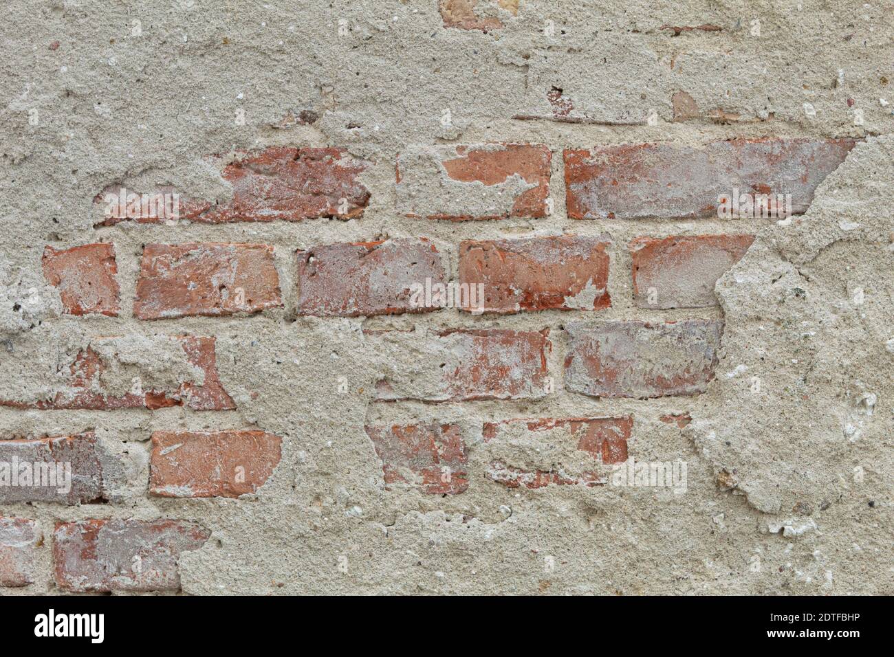 La textura de la piedra y el yeso caído. Caída de yeso y pared de piedra roja Foto de stock