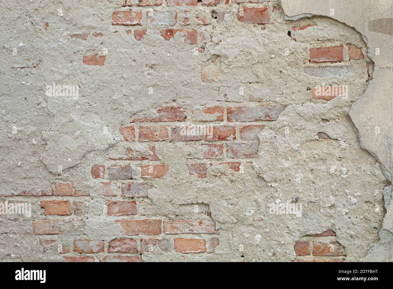 La textura de la piedra y el yeso caído. Caída de yeso y pared de piedra roja Foto de stock