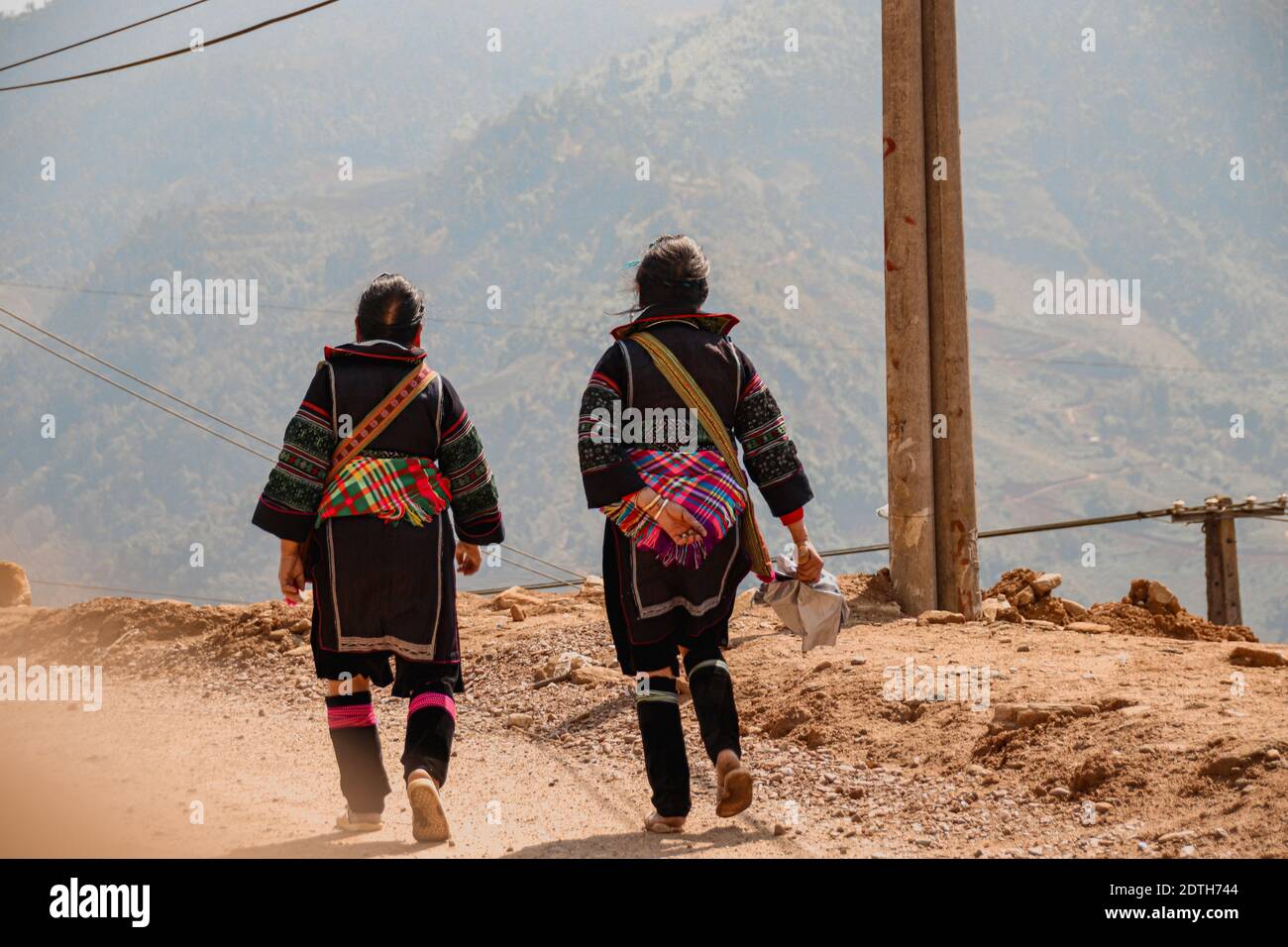 Las mujeres de la tribu Hmong llevaban su ropa tradicional mientras caminaban de regreso a la aldea Lao Cai en Sa pa, Vietnam Foto de stock