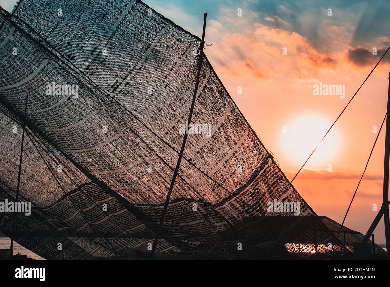 Redes de peces contra el cielo de la puesta de sol, mostrando la vida cotidiana y la cultura en el pueblo pesquero de Ben Tre, Mekong Delta Vietnam Foto de stock