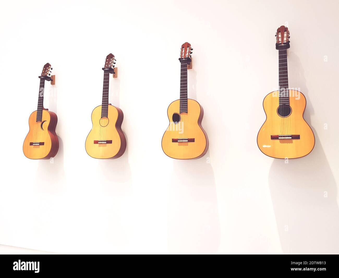 Guitarras colgadas contra la pared blanca Fotografía de stock - Alamy