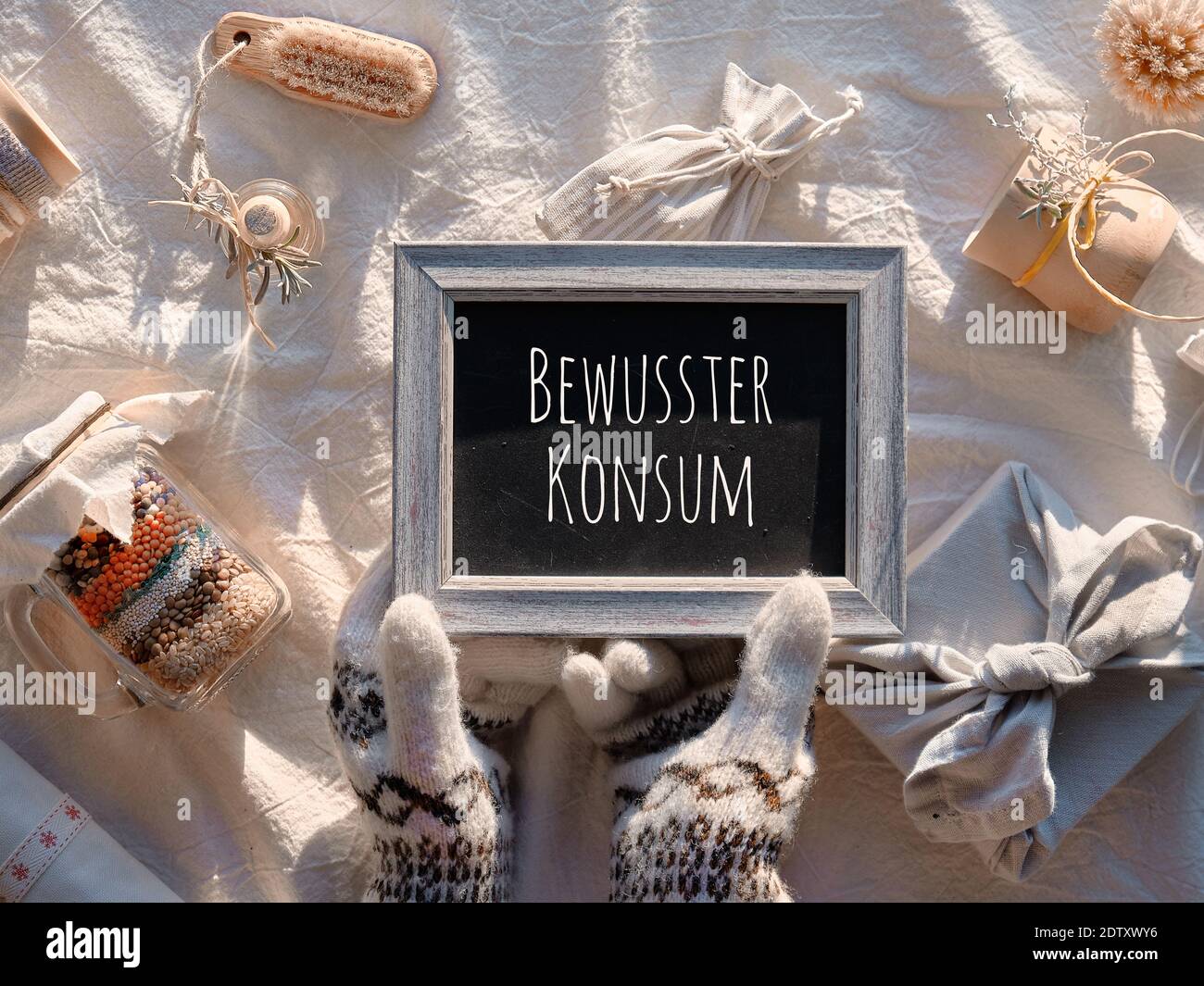 Pizarra con texto Bewusster Konsum en alemán que significa consumo consciente. Regalos ecológicos para las vacaciones de invierno incluyendo Navidad Foto de stock