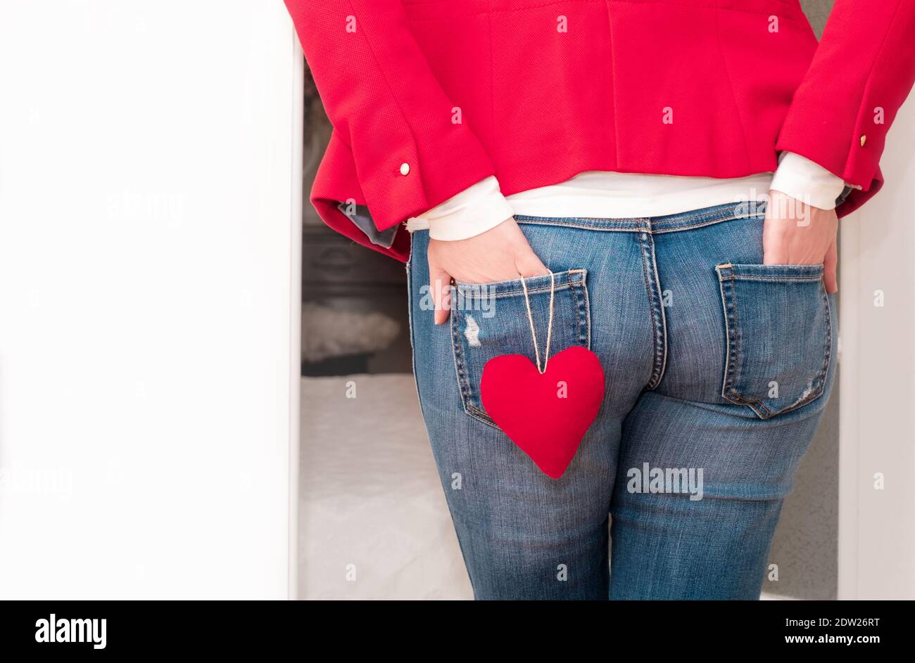 Las manos de la mujer en los bolsillos traseros de jeans con el corazón  rojo grande del día de San Valentín cerca de la puerta blanca Fotografía de  stock - Alamy