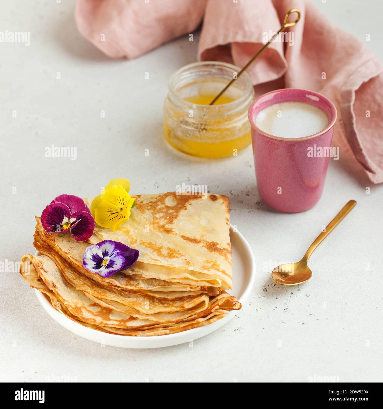 Crepes franceses, panqueques decorados con flores, una taza de capuchino y  miel. Concepto de desayuno, postre Fotografía de stock - Alamy