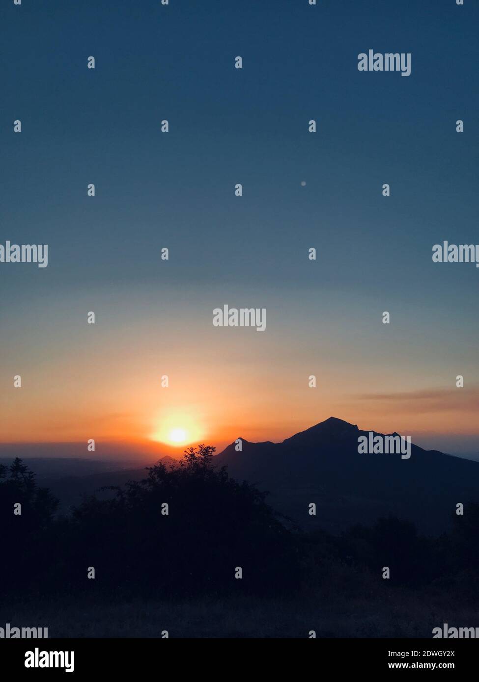Vista panorámica de las montañas de silueta contra el cielo durante la puesta de sol Foto de stock
