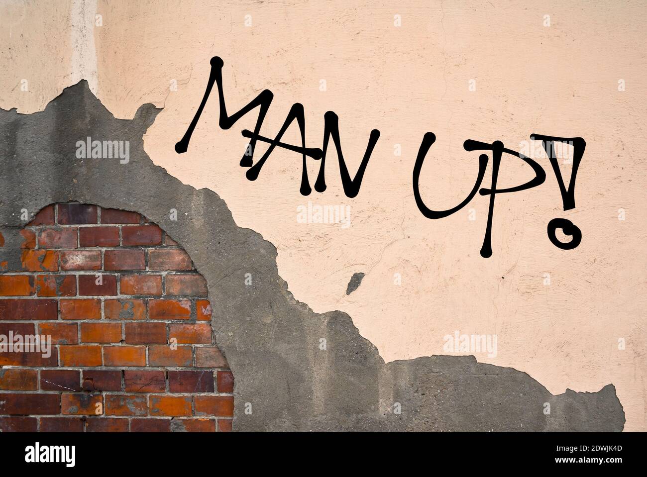 Man Up - graffiti manuscrito rociado en la pared - motivación y challege para ser fuerte, valiente, valiente y valiente hombre en lugar de ser débil y un Foto de stock
