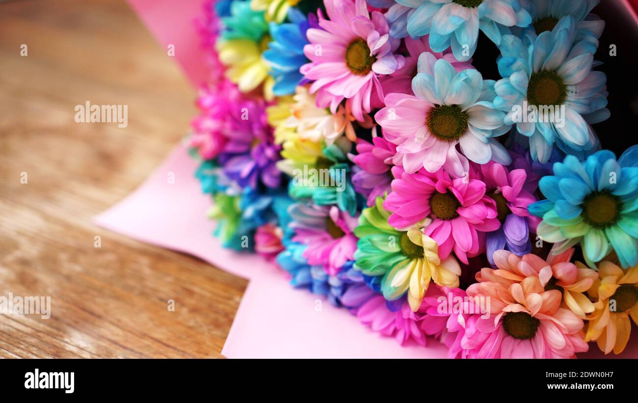 De cerca flores arcoiris flores brillante ramo sobre fondo de madera  Fotografía de stock - Alamy