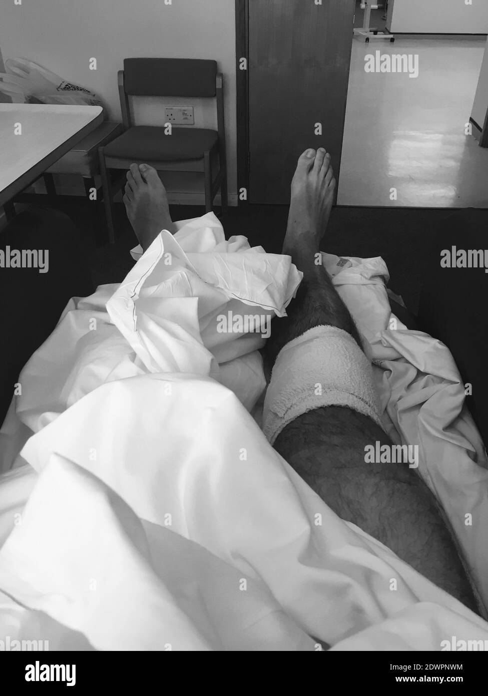 Sección baja de hombre atado en cama después de la operación de rodilla  Fotografía de stock - Alamy