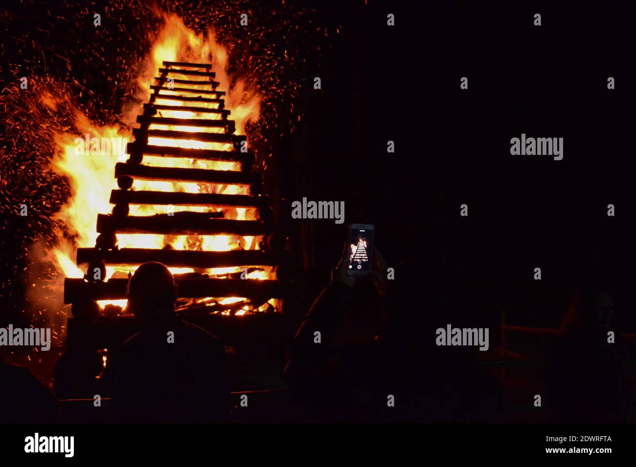 Vista trasera de personas en fuego iluminado por la noche Foto de stock