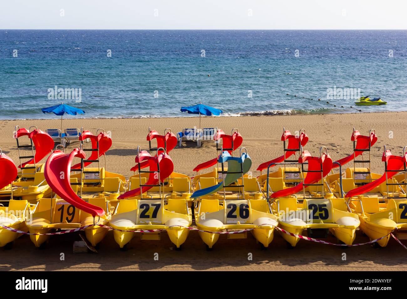 Coloridos botes a pedal con tobogán en playa vacía en Puerto del Carmen,  Lanzarote. Crisis turística, consecuencias de bloqueo pandémico, recreación  de verano Fotografía de stock - Alamy