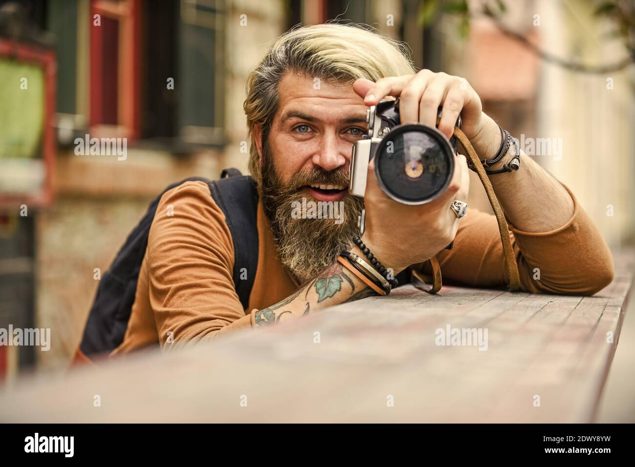 solo sonríe. consejos de viaje. fotógrafo profesional usa una cámara de  época. hombre de cintura baja toma fotos. foto al aire libre. hombre brutal  viajero con cámara retro. fotografía en la vida