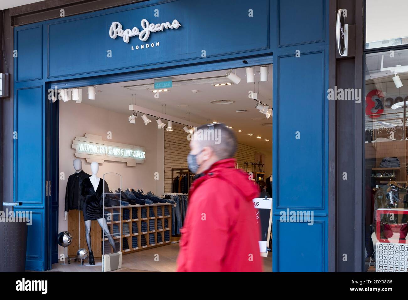 Un hombre que lleva una máscara pasea por los Pepe Jeans en el centro  comercial Bonaire Fotografía de stock - Alamy