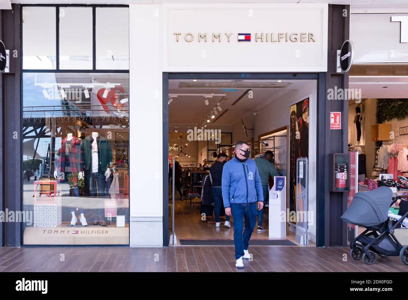 Valencia, España. 23 de diciembre de 2020. Un hombre que lleva una máscara  sale de la tienda Tommy Hilfiger en el centro comercial Bonaire. Crédito:  Xisco Navarro/SOPA Images/ZUMA Wire/Alamy Live News Fotografía