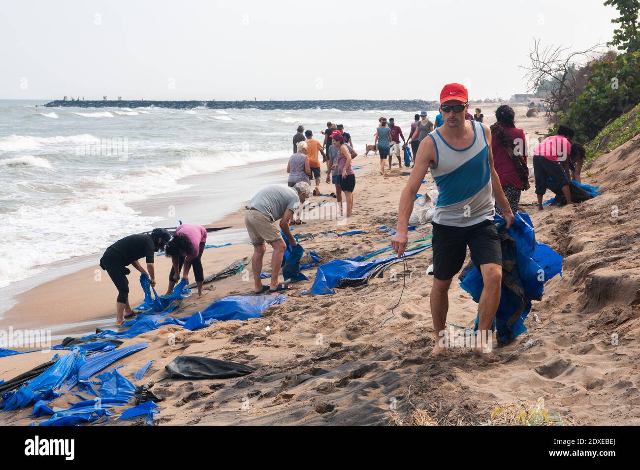 AUROVILLE, INDIA - 2020 de diciembre: Día de limpieza para eliminar el plástico que queda en la playa como protección contra la erosión del mar Foto de stock