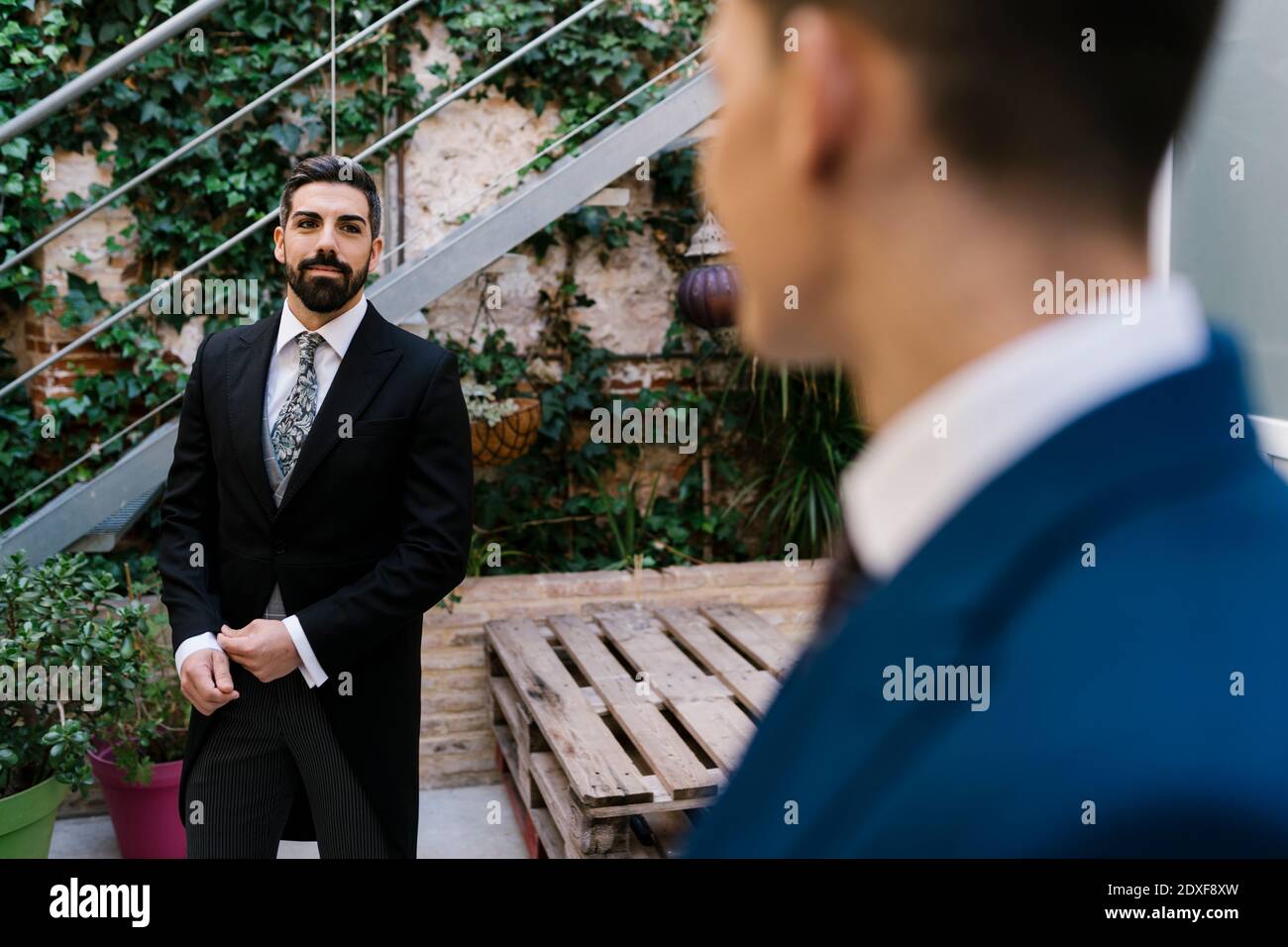 Jóvenes vestidos bien en el jardín el día de la boda Foto de stock