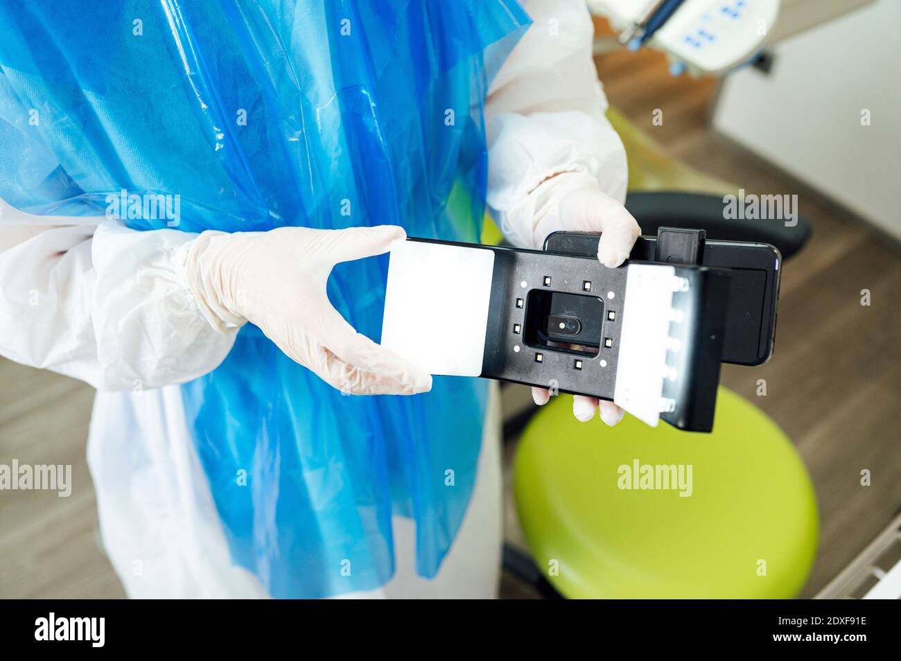 Dentista usando ropa de trabajo protectora usando fotografía dental móvil  Fotografía de stock - Alamy