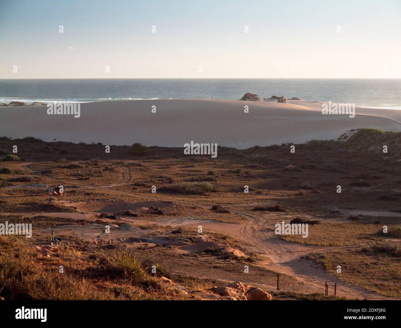 Luz nocturna cálida con vistas a las dunas de arena revegetadas hacia el Océano Índico, Gnaraloo, Costa Gascoyne, Australia Occidental Foto de stock