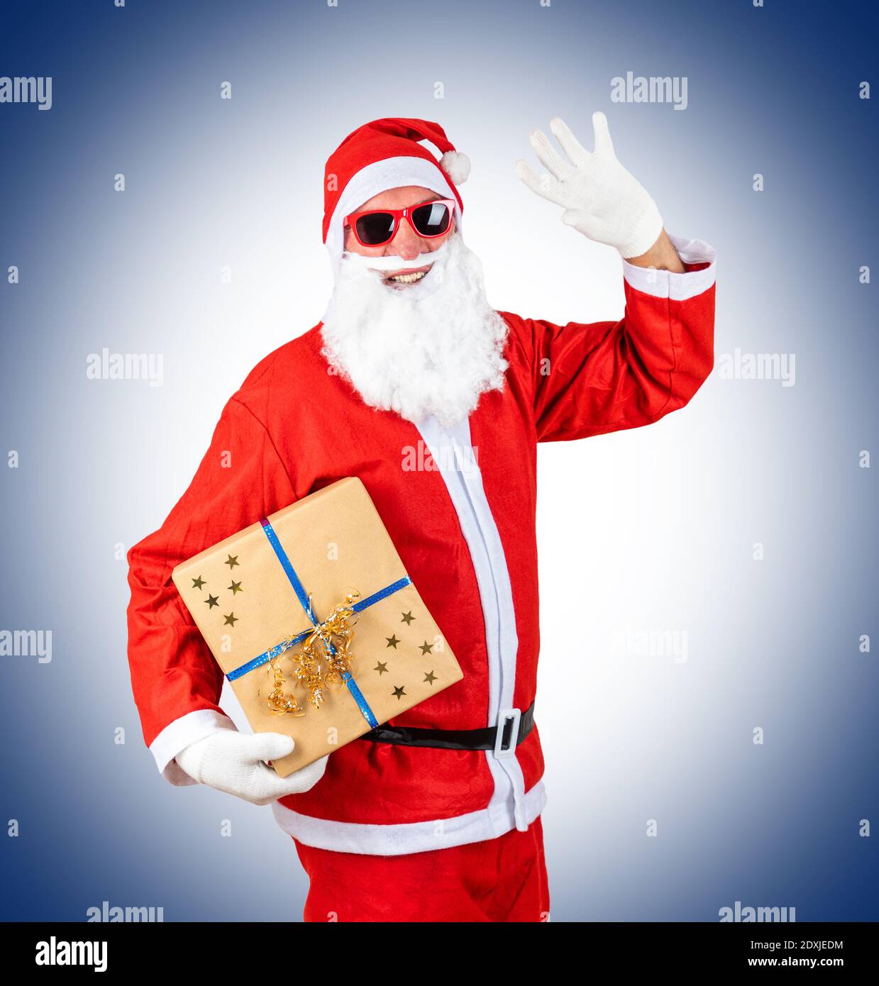 Retrato del hombre disfrazado de Papá Noel sosteniendo un regalo contra  fondo azul Fotografía de stock - Alamy