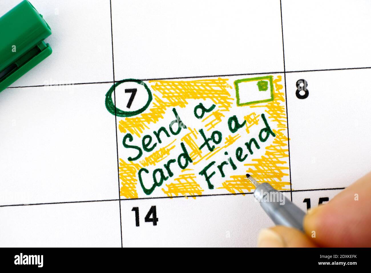 Mujer dedos con lápiz escribir recordatorio Enviar una tarjeta a un amigo día en el calendario. Febrero de 07 Foto de stock