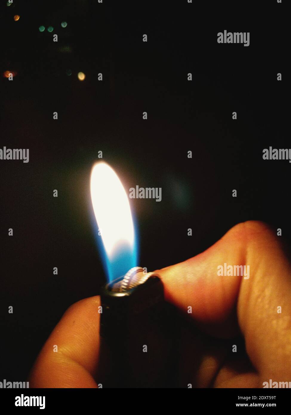 Primer plano de la mano encendiendo el encendedor de cigarrillos por la  noche Fotografía de stock - Alamy