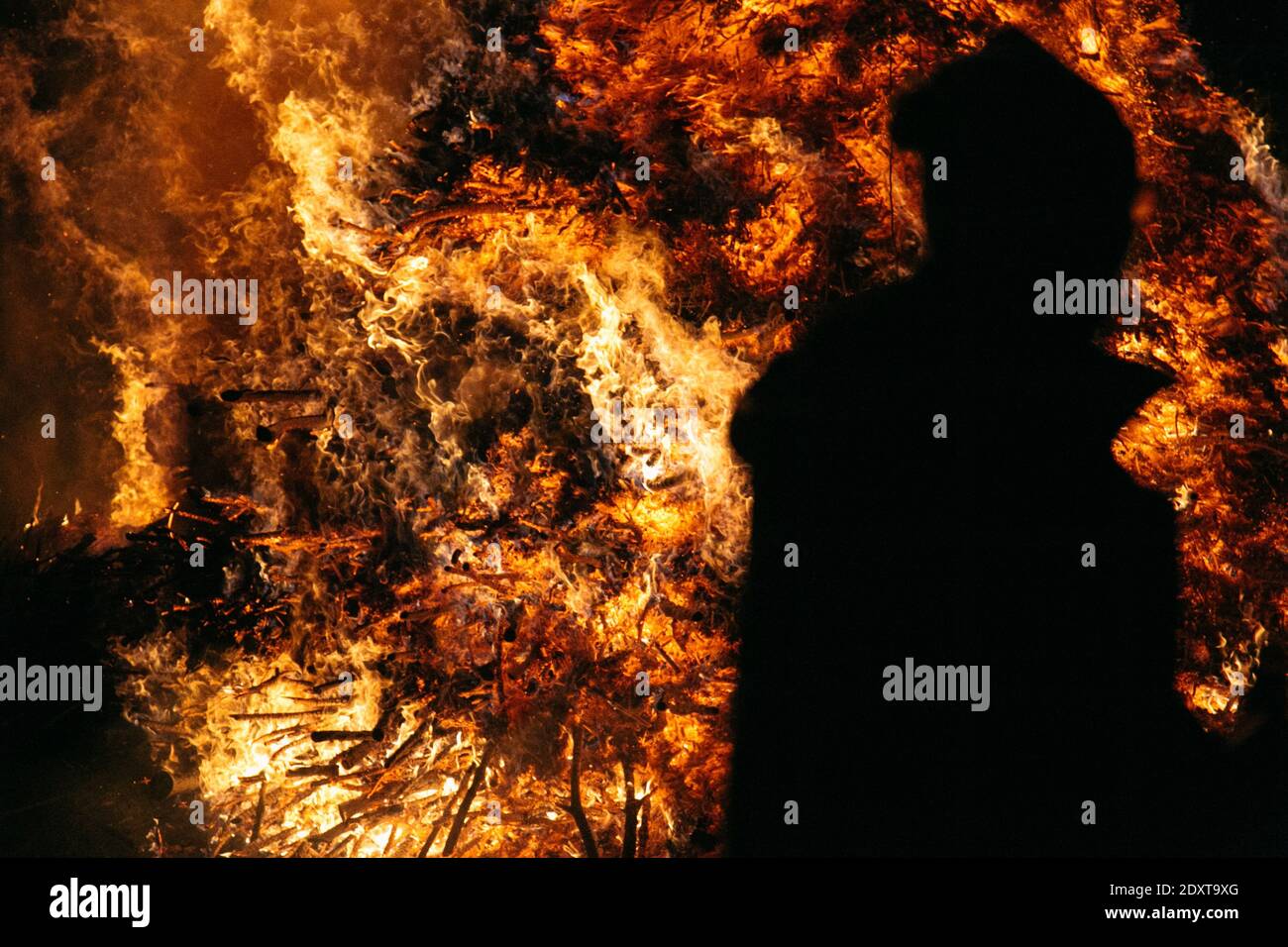 Silueta de la persona contra el fuego por la noche Foto de stock