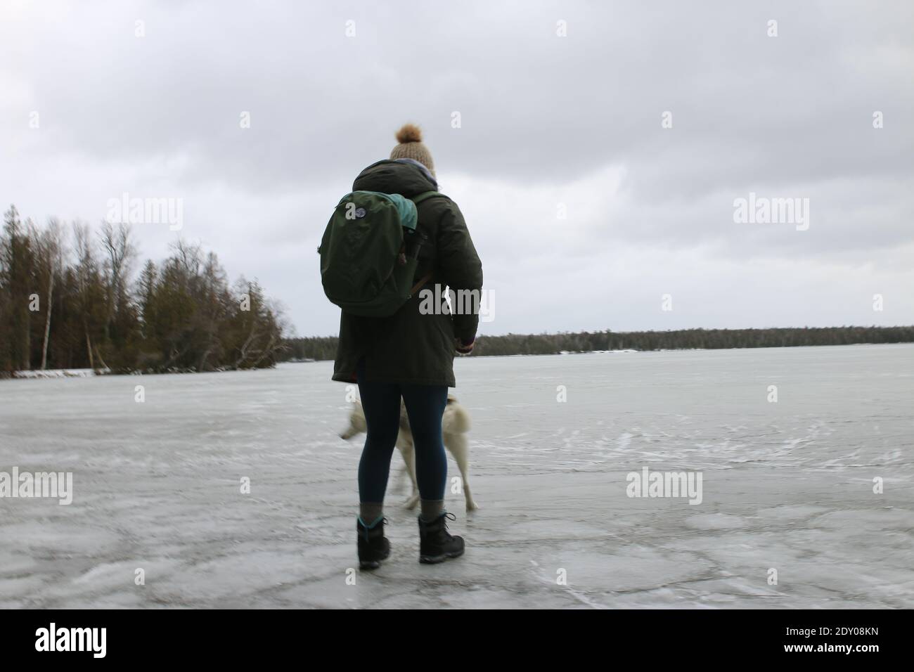 Tobermory Canadá, diciembre de 16 2020: Foto editorial de una mujer de pie  en el hielo senderismo con todo su equipo y perro. El senderismo en invierno  es divertido en Canadá Fotografía