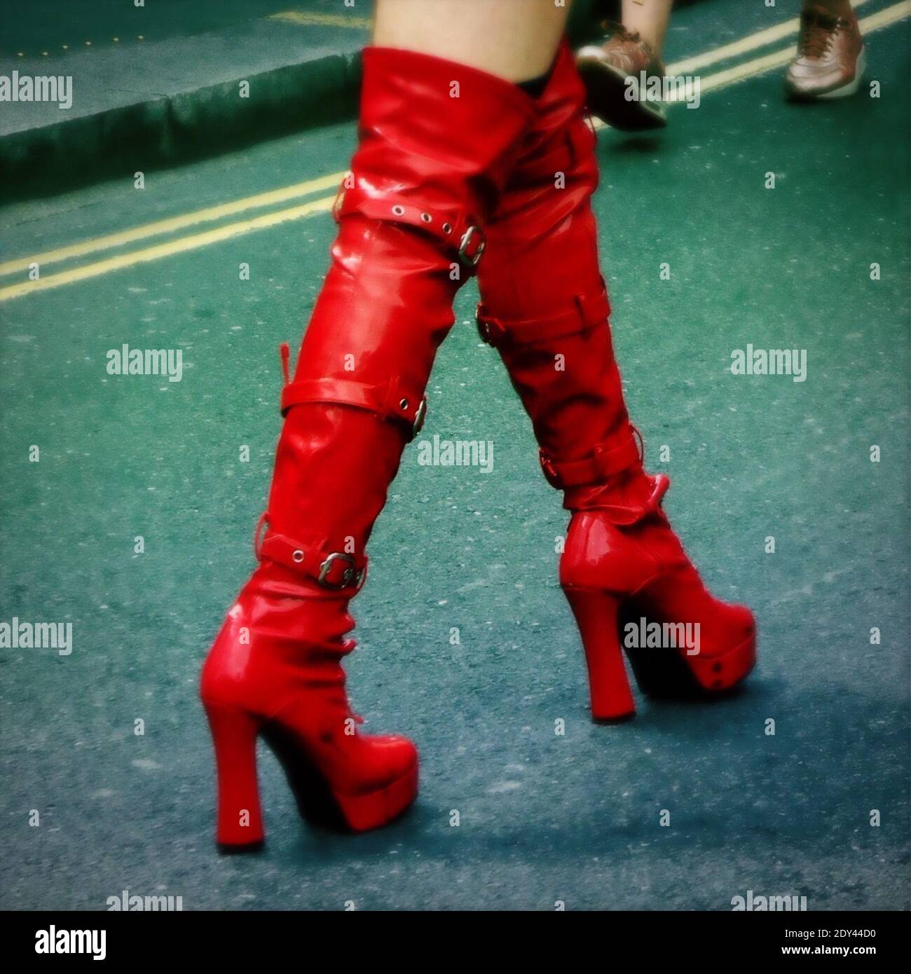 Sección baja de una persona caminando con botas rojas Fotografía de stock -  Alamy