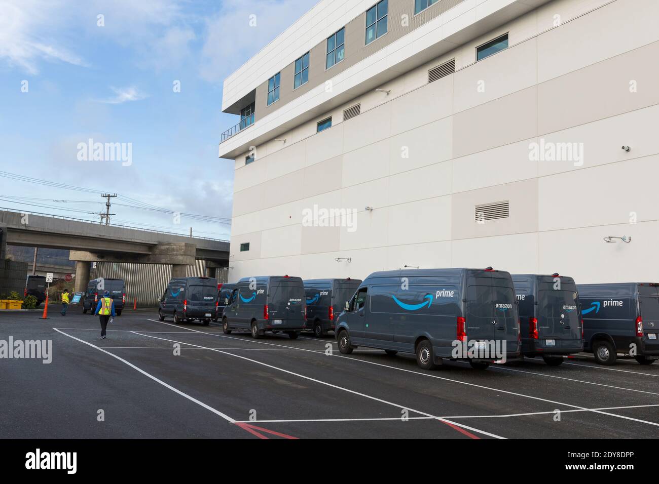 Los empleados guían una flota de furgonetas de entrega cuando salen del centro logístico de Amazon en el sur de Seattle el miércoles, 23 de diciembre de 2020. El escuadrón 500,000 Foto de stock