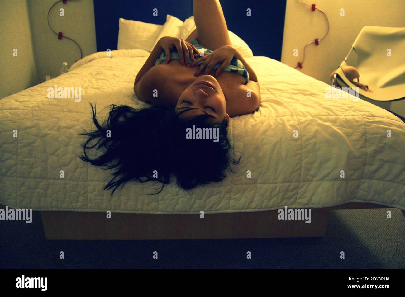 Una sensual mujer acostada en la cama en casa Fotografía de stock - Alamy