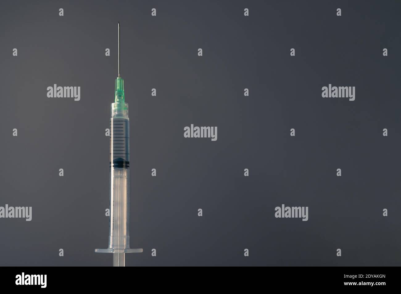 Primer plano de una jeringa de inyección sobre fondo gris - vacuna covid Foto de stock