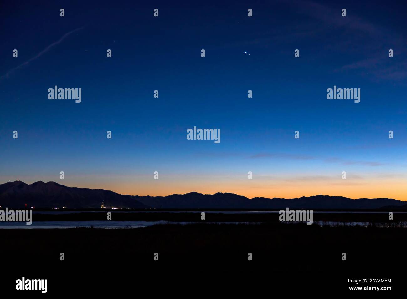 Júpiter y Saturno parecen colgar en el cielo sobre las montañas al oeste de Farmington, Utah, EE.UU. Durante la "Gran conjunción" de los planetas. Foto de stock