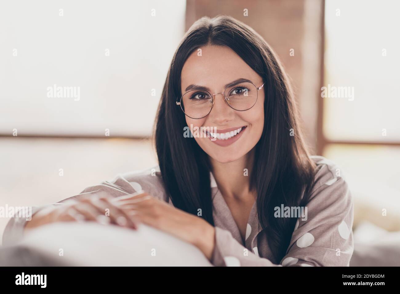 Retrato de niña bastante optimista llevar gafas de pijama en casa Foto de stock