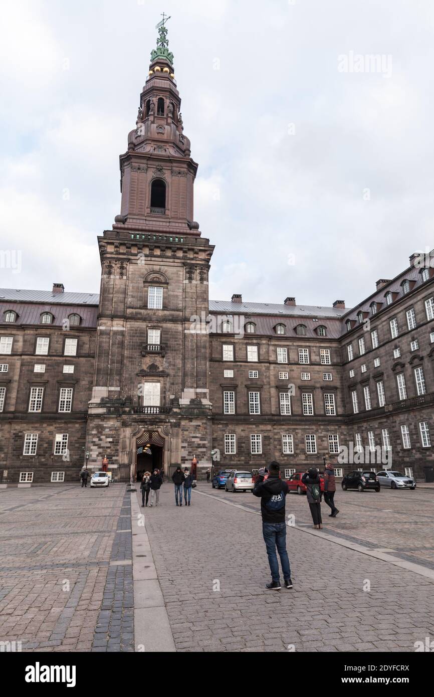 Copenhague, Dinamarca - 10 de diciembre de 2017: Los turistas están frente al Palacio Christiansborg, un palacio y edificio del gobierno en Copenhague. Fot vertical Foto de stock