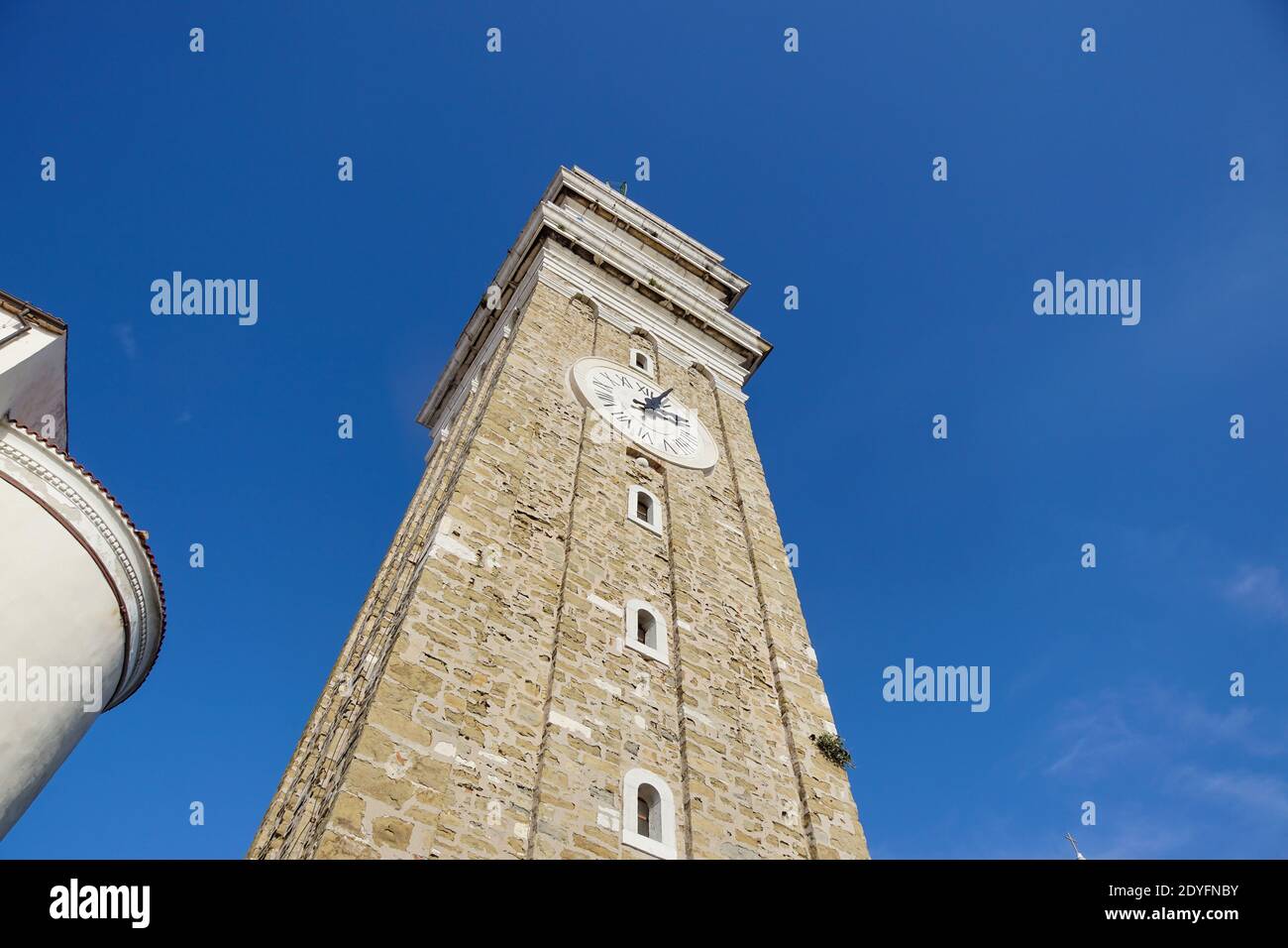 La torre del reloj con el cielo azul en italia. Torre medieval Foto de stock