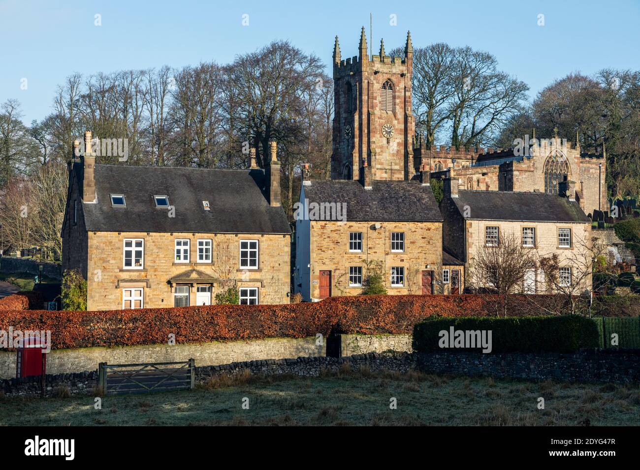 Casas rurales y la Iglesia de San Bartolomé en el pueblo del Distrito de los Picos de Hartington, Derbyshire Foto de stock