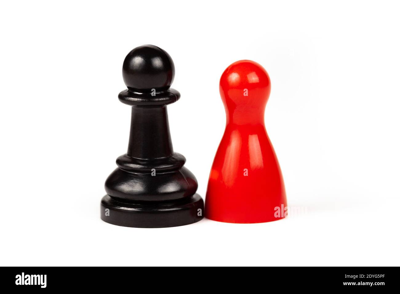 Diferencias concepto de unión pareada, dos piezas. Pieza de juego roja y un peón de ajedrez negro de pie juntos, aislados en blanco, cortado. Diversidad Foto de stock