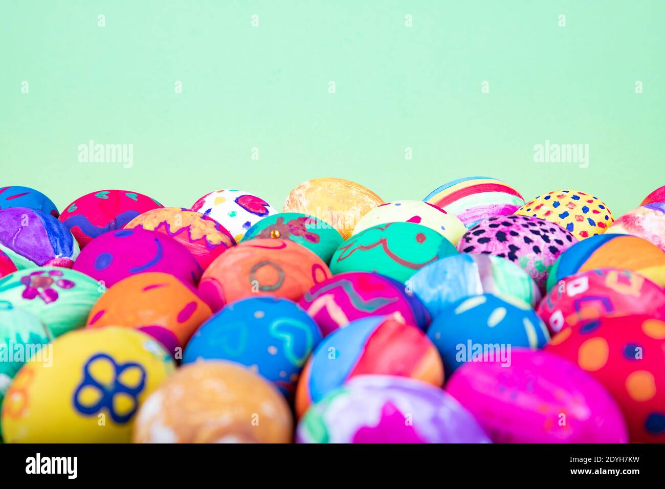 huevos pintados antes de fondo verde, motivo de pascua Foto de stock