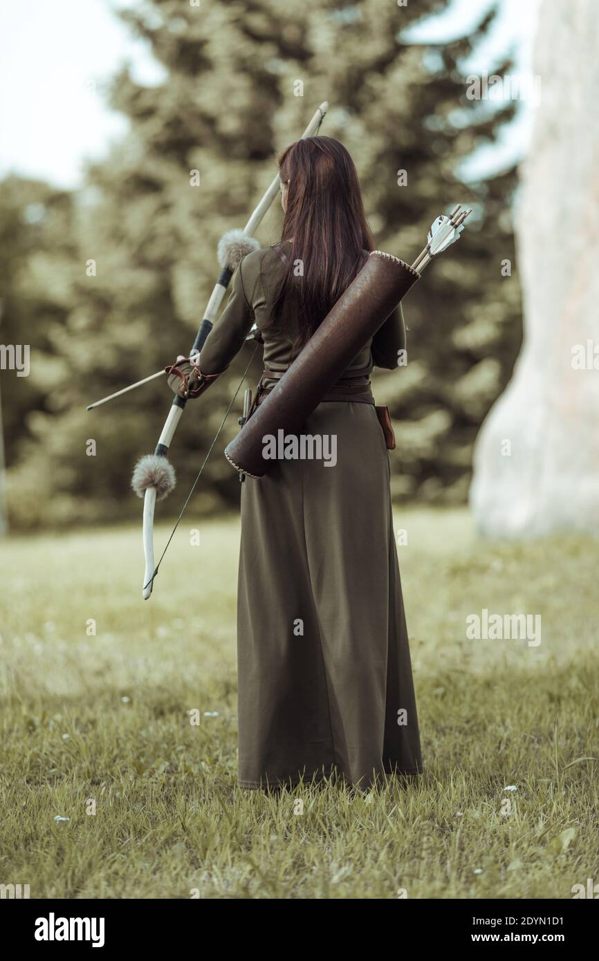 La arquera de mujer joven con traje verde medieval está con ella atrás  Fotografía de stock - Alamy
