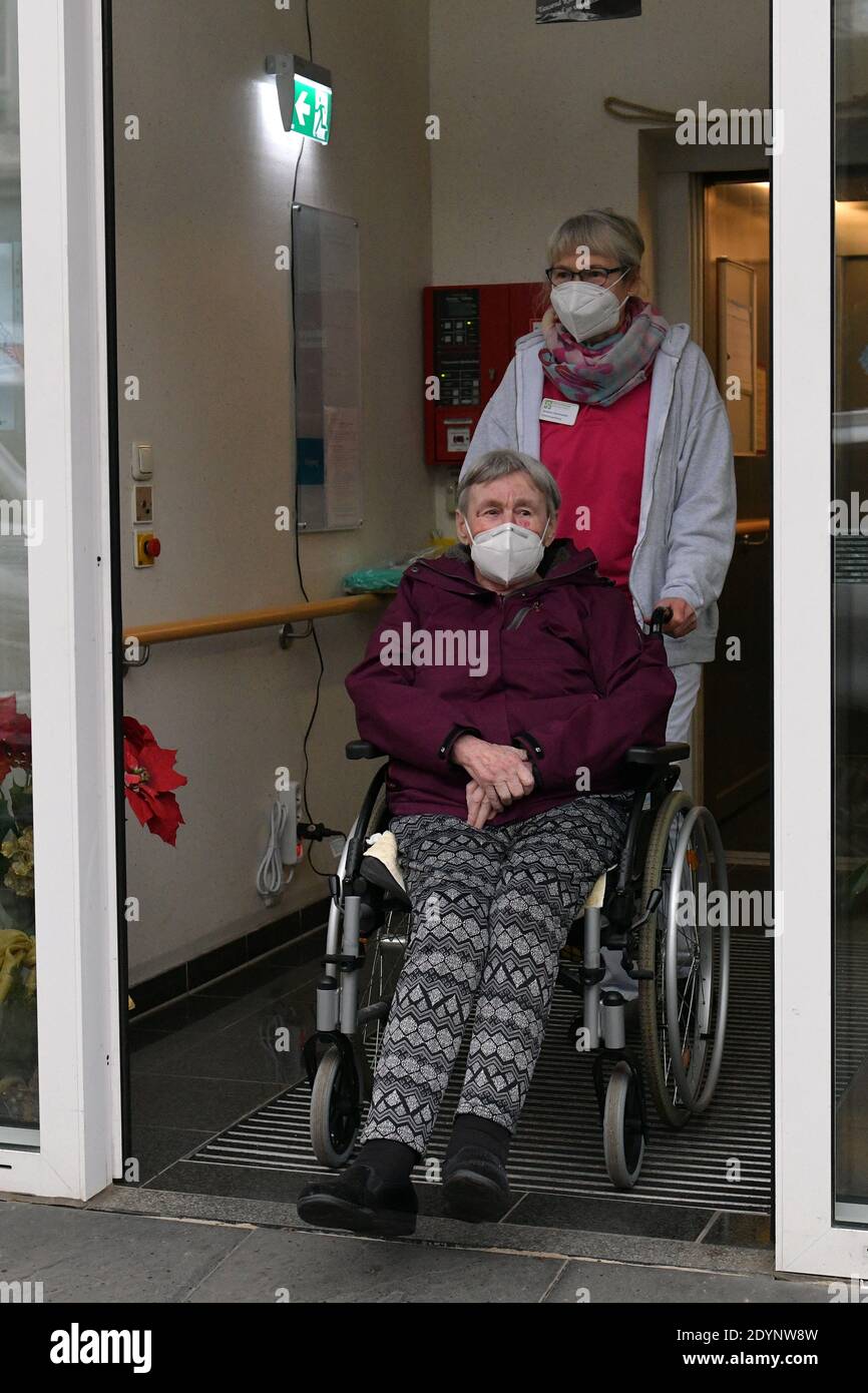 Bremen, Alemania. 27 de diciembre de 2020. Susanne Hachmeister, jefa de la  instalación, conduce a la ciudadana mayor Alize Oesselmann (en silla de  ruedas) a la puerta de una casa de retiro.
