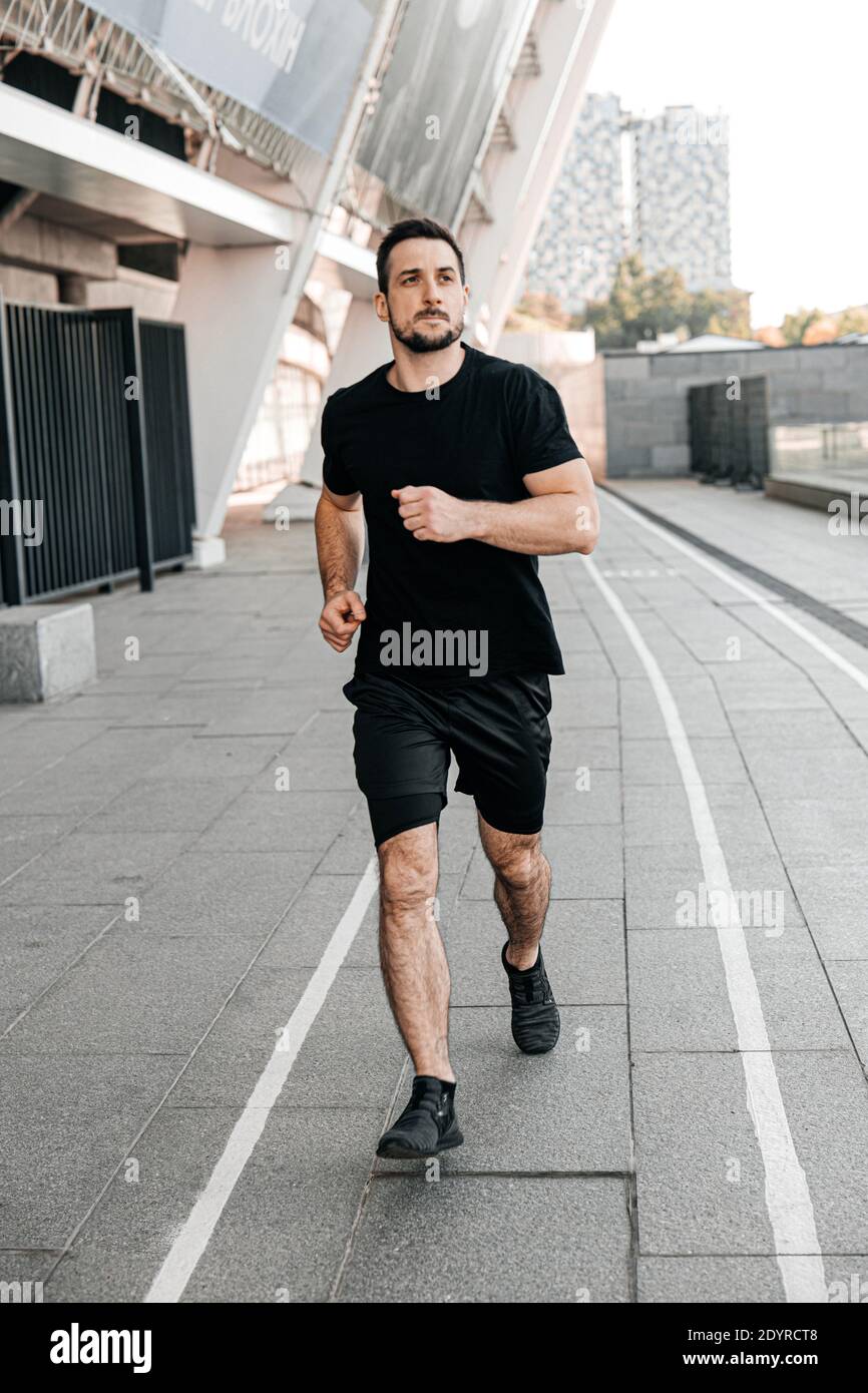 Hombre atlético jogging en la ciudad. Estilo de vida saludable. Hombre  corriendo. Estilo de vida urbano. Vida activa. Gimnasio al aire libre. Ropa  deportiva negra. Hombre feliz Fotografía de stock - Alamy