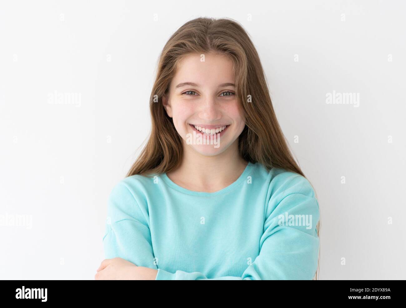 Retrato de una niña adolescente sonriente con el pelo largo suelto fondo blanco de la pared Foto de stock