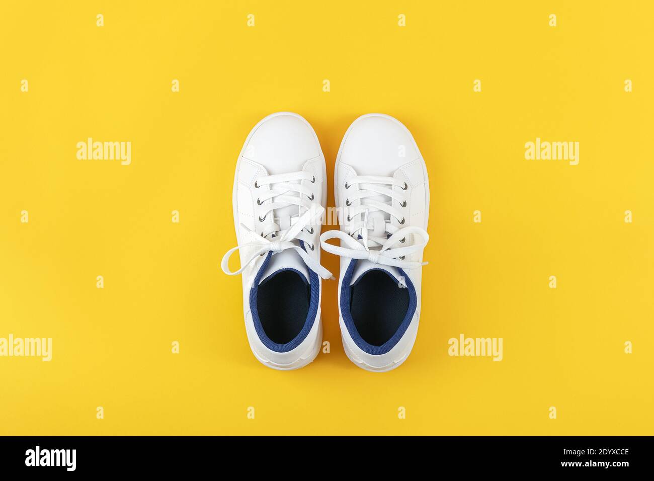 Zapatos deportivos blancos, zapatillas de deporte con cordones fondo amarillo. de estilo de vida Vista superior plano espacio de copia Fotografía de stock - Alamy