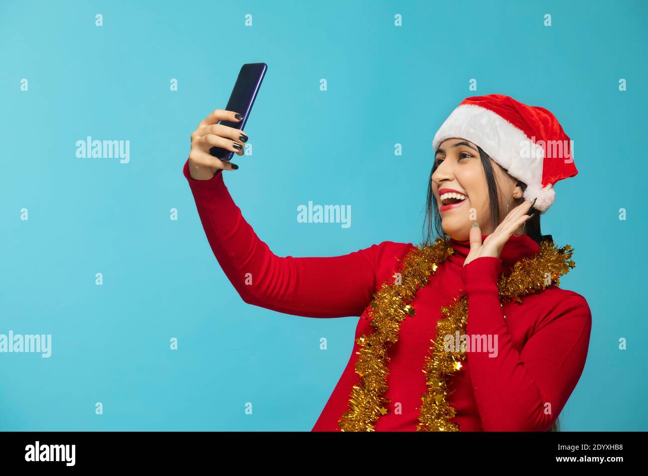 Mujer tomando selfie con el teléfono móvil con sombrero de Navidad Foto de stock