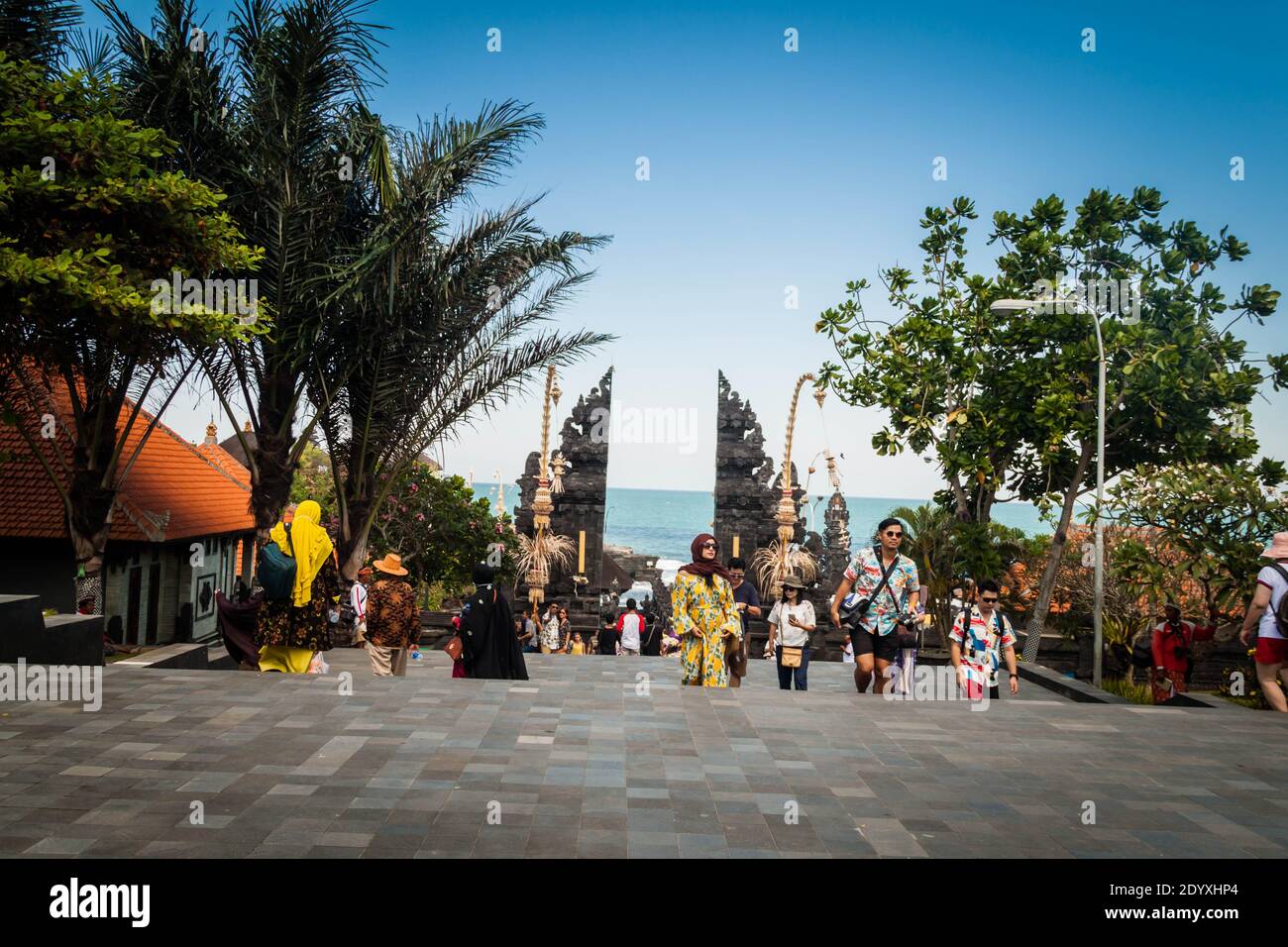 Una imagen angular de la vista de la calle de Tanah Puerta del Templo de Lot mientras los turistas están caminando Foto de stock