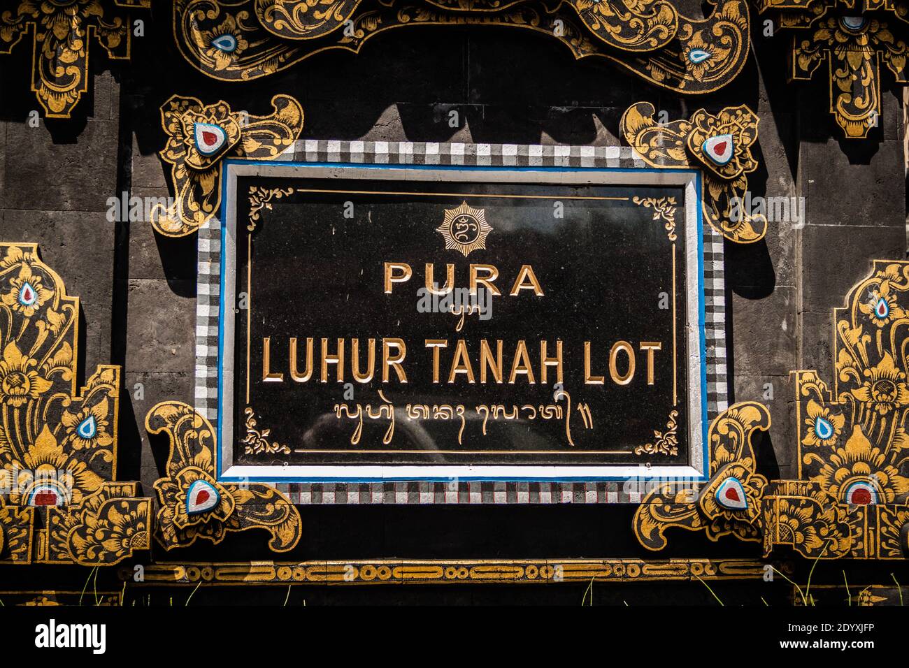 La señal de entrada del Templo Tanah Lot en un negro marco con detalles dorados Foto de stock